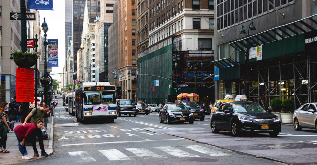 A vibrant New York City street scene with traffic, skyscrapers, and pedestrians crossing.