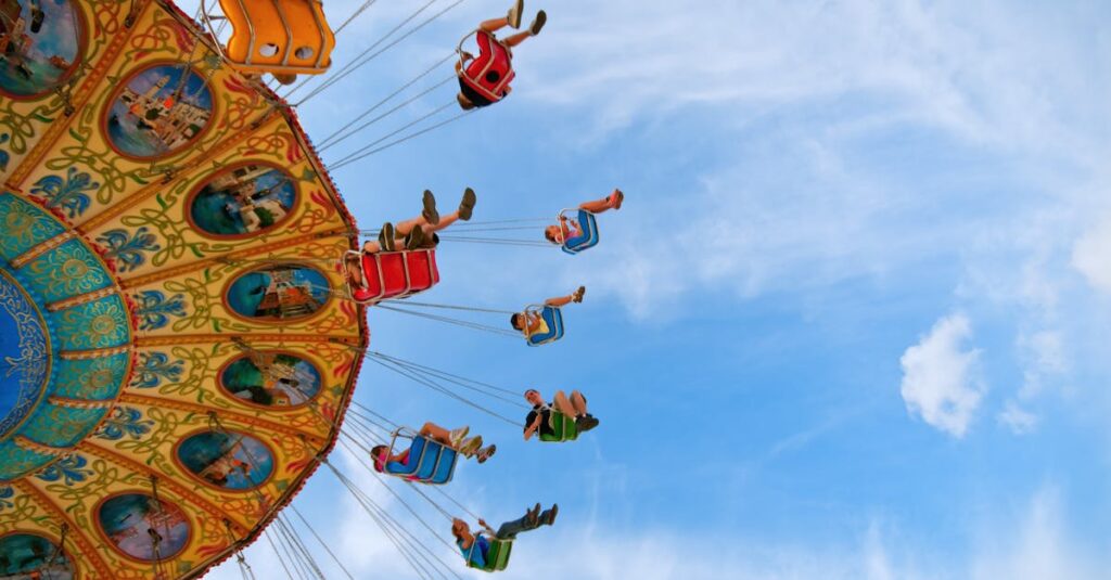 Colorful swing ride at an amusement park with people enjoying a thrilling day under the clear blue sky.