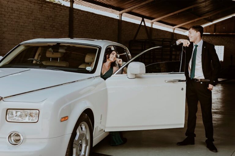 Woman Sitting inside a Rolls-Royce and Man in a Suit Standing by the Door