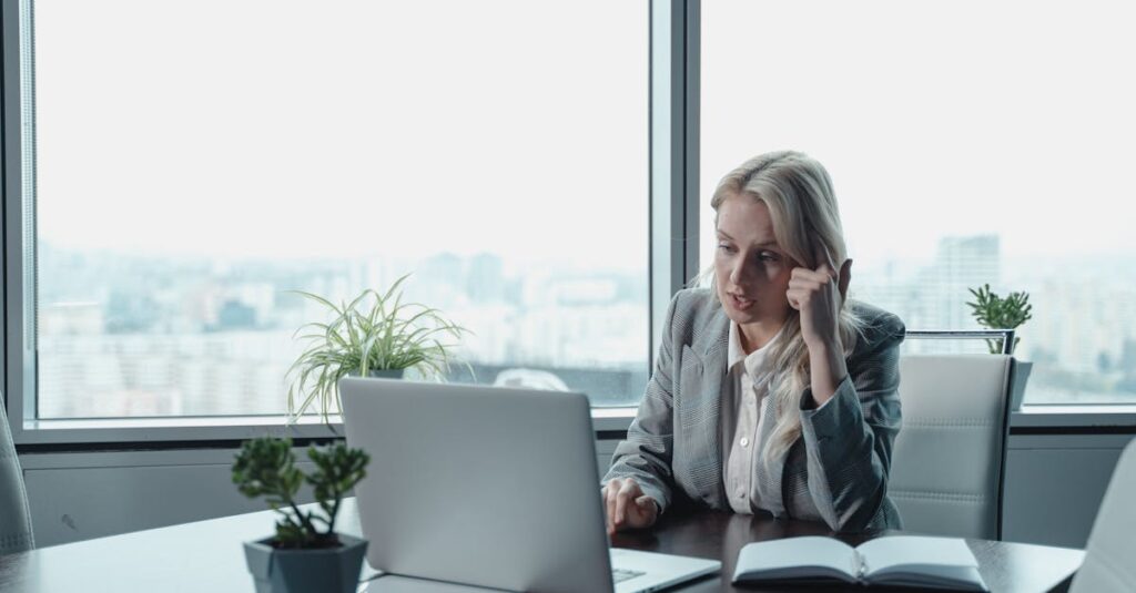 Woman in Gray Blazer Sitting In Front of Gray Laptop Computer