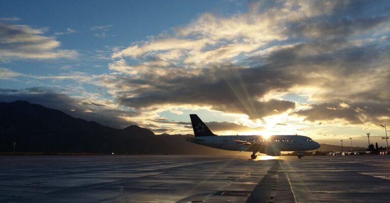 A beautiful silhouette of an airplane on a runway during a vibrant sunset at Čilipi Airport, Croatia.