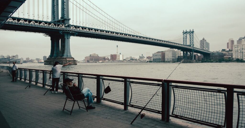 Individuals enjoying a leisurely day by the Manhattan Bridge, New York City waterfront.