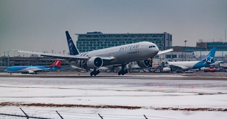 An airplane takes off at a snowy airport, showcasing travel and aviation in the winter season.