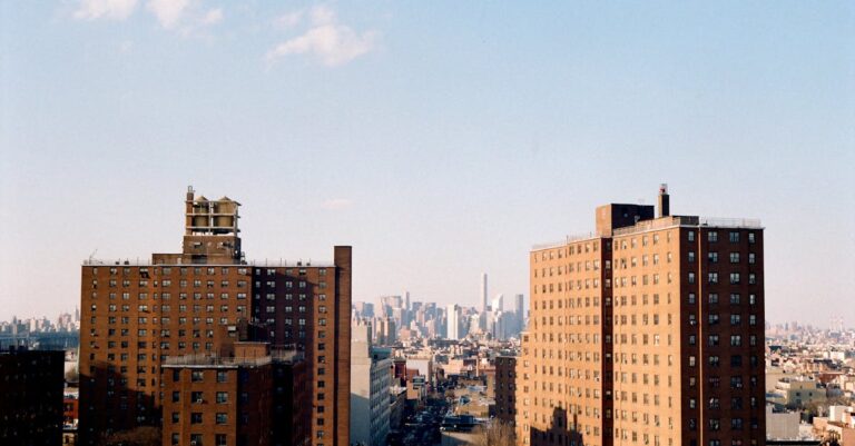 A scenic view of New York apartment buildings with a city skyline in the background.