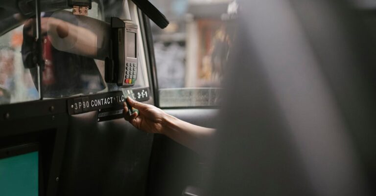 A passenger makes a payment using a card in a taxi with a handheld payment terminal.