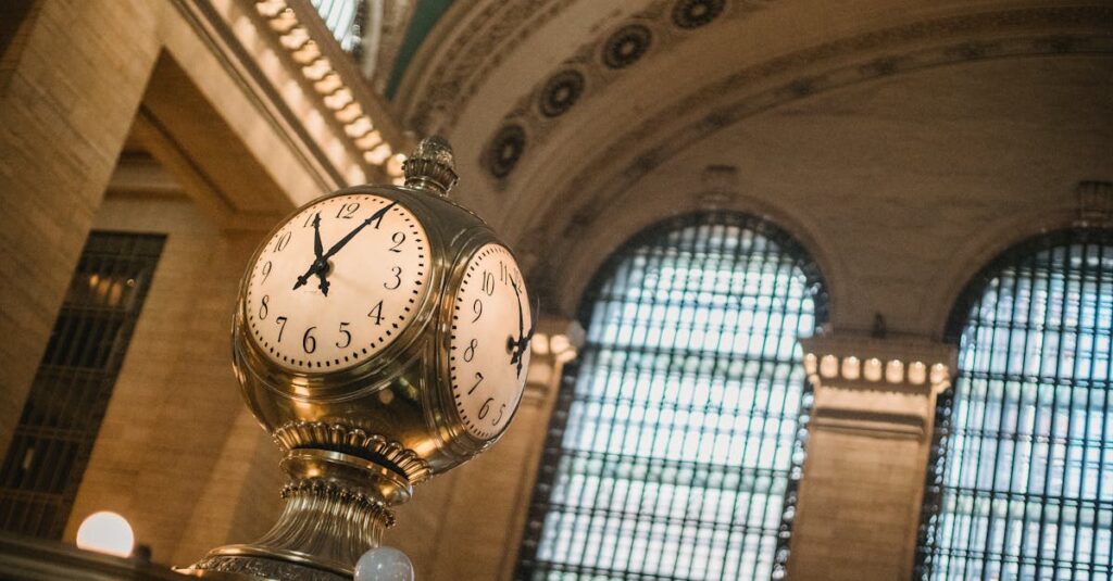 From below of vintage golden clock placed in hallway with aged interior with ornamental walls and windows and high ceilings placed in Grand Central Terminal in New Your City in daytime