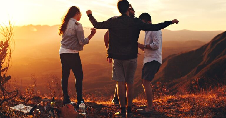 Joyful group of young adults enjoying a sunset view in a mountainous landscape in Brazil.