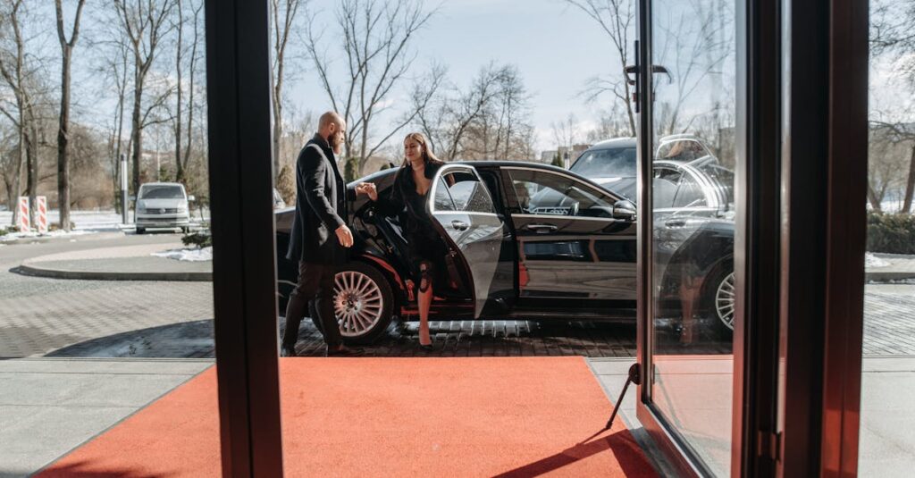 A couple stepping out of a luxury car onto a red carpet in an upscale outdoor setting.