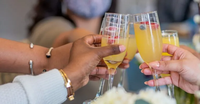 A diverse group toasting with mimosas in Washington, DC indoors.