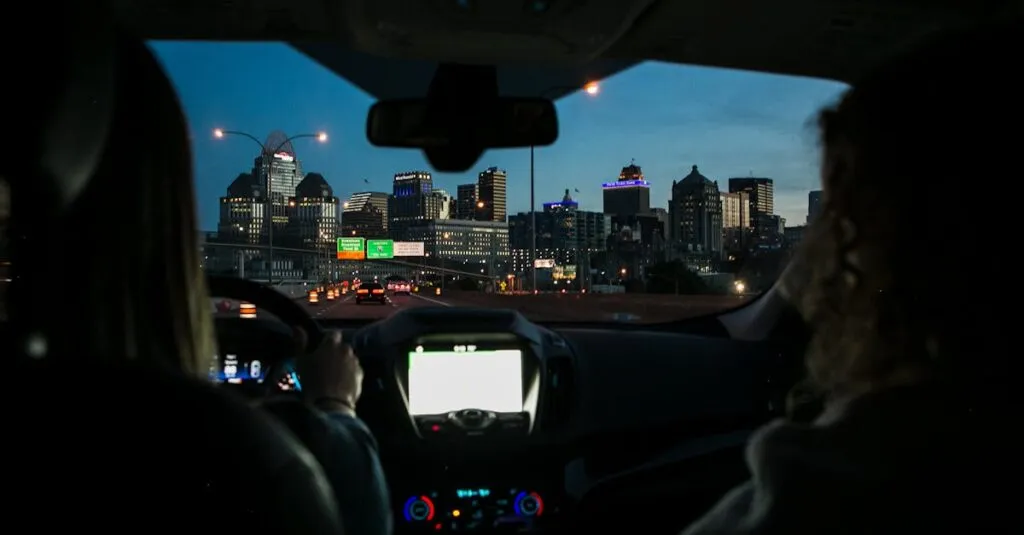 View of city skyline during night drive, captured through car windshield.