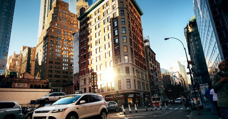 A bustling New York City street with towering buildings at golden hour, capturing urban life.