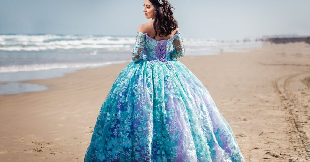 A woman in a stunning blue ball gown poses on a serene beach, showcasing elegance and beauty.