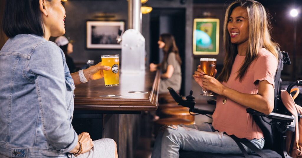 Two women enjoying drinks at a bar, smiling and socializing.