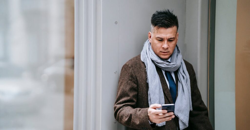 A stylish businessman using a smartphone outside in winter attire, conveying modernity and technology.