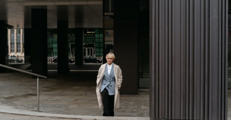 Confident businesswoman in formal wear standing outside modern office building.