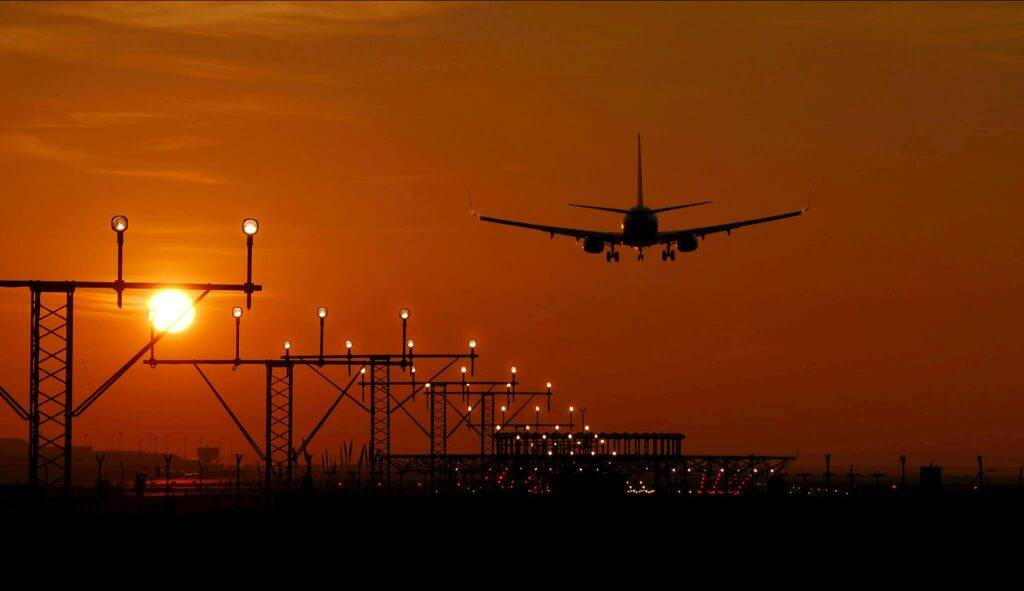 Airport Car Service Near By: 7 Honest 2027 Tests 1 September 19, 2026 Silhouette of an airplane landing during sunset at Barcelona airport, with a vibrant orange sky.