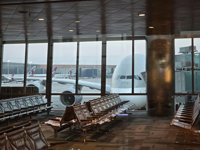 A passenger plane at Hamad International Airport in Doha with empty seating area in the foreground.