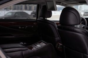 Elegant interior of a luxury vehicle with black leather seats and wood paneling. Perfect for travel and comfort images.