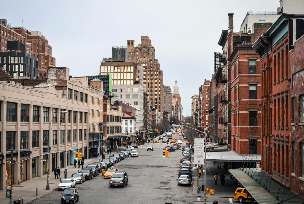 Busy New York City Street Showcasing Urban Architecture And Bustling Traffic At Daytime.