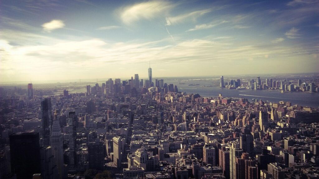 Stunning aerial view of New York City skyline with the Hudson River at dusk, highlighting iconic skyscrapers and urban landscape.