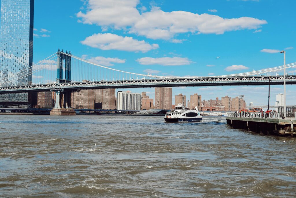 Daytime view of the Manhattan Bridge and ferry on the East River, New York City.