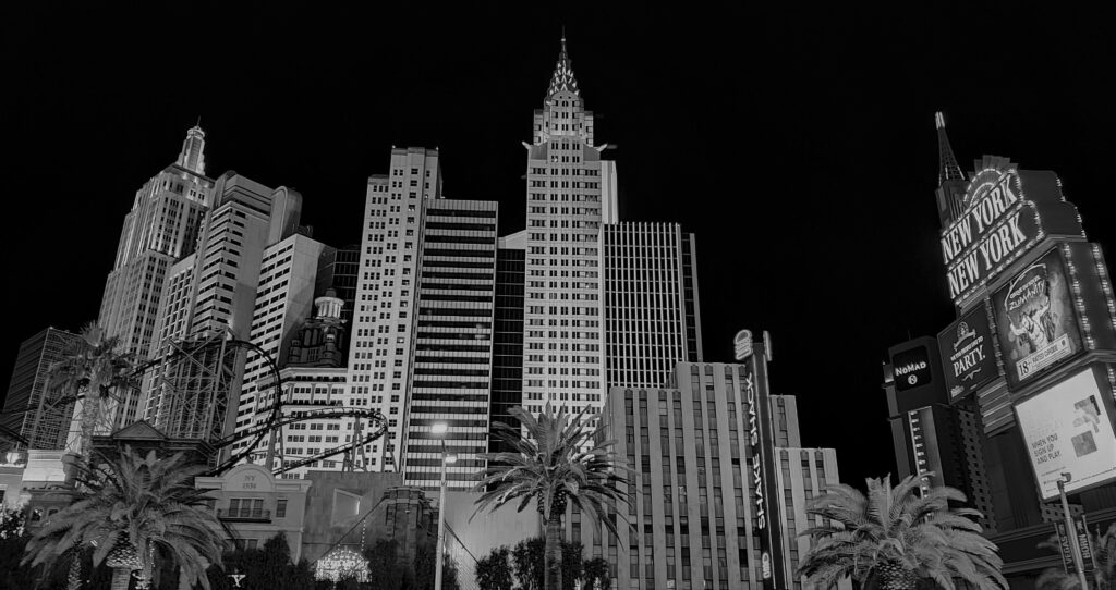 Black and white night view of the Las Vegas skyline featuring the New York-New York hotel.
