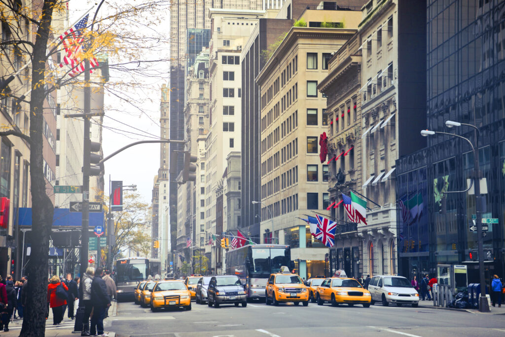 NYC 10271 Car Service: 7 Honest Facts for 2026 4 September 24, 2026 Busy New York City street with iconic taxis, buildings, and international flags