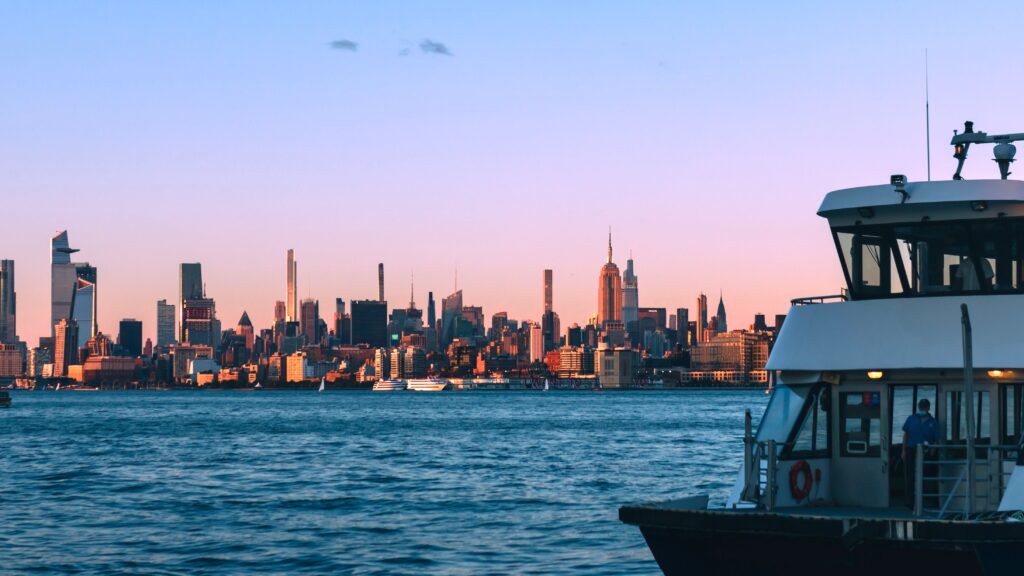 Transportation Manhattan Cruise Terminal to LGA: 7 Honest Facts for 2026 2 September 26, 2026 View of New York City's skyline during dusk with a ferry in the foreground, capturing urban and water elements.