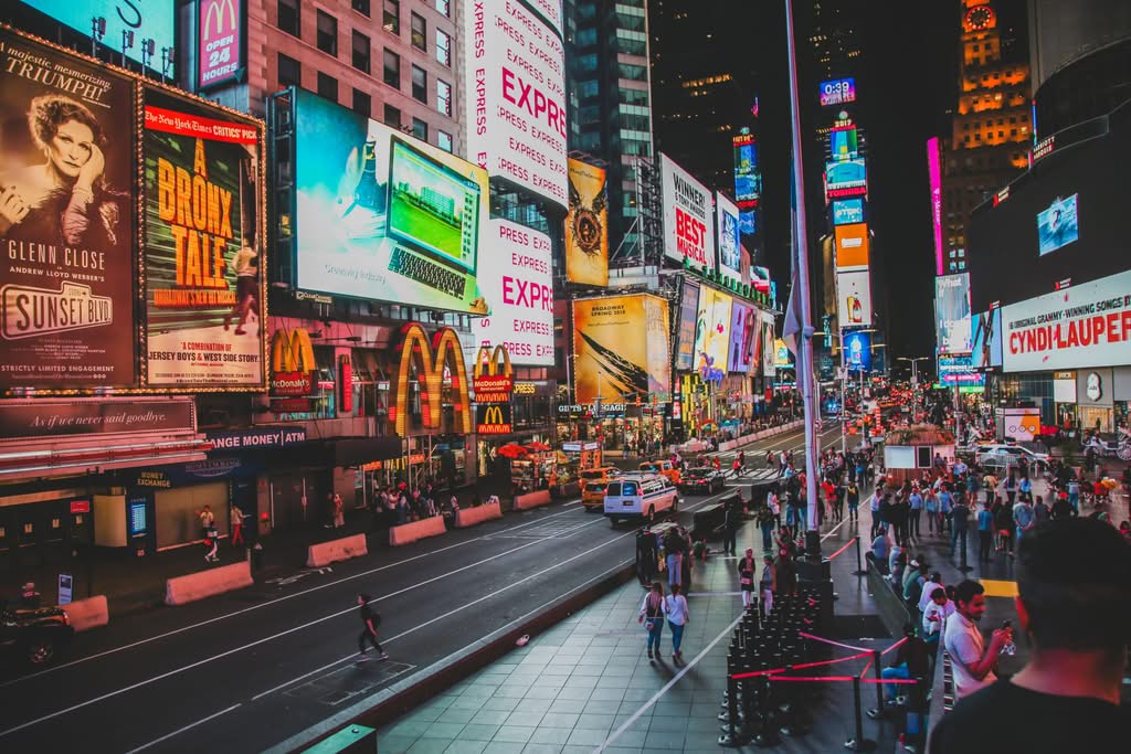 Dynamic view of Times Square nightlife with crowds and illuminated billboards in New York City.