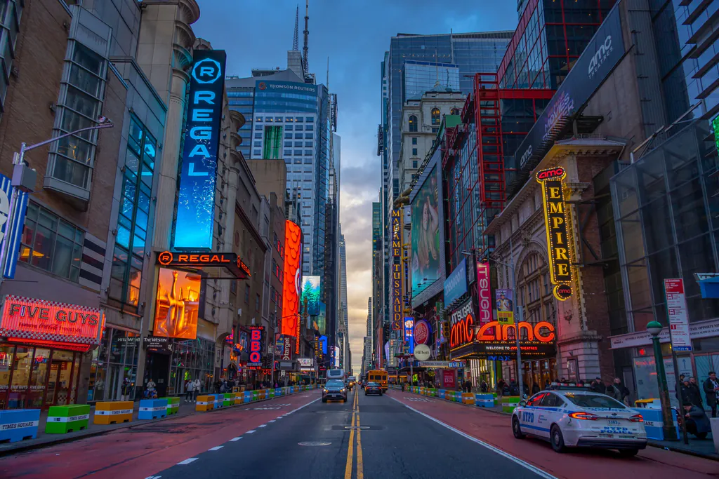 Dynamic street view of Times Square in New York City at dusk, showcasing vibrant lights and bustling atmosphere.
