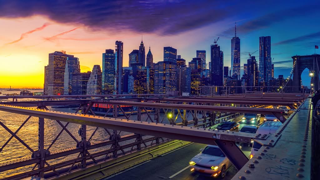 Getting From Manhattan to JFK: 7 Honest Options 8 September 19, 2026 Captivating view of New York City skyline and Brooklyn Bridge illuminated at sunset.