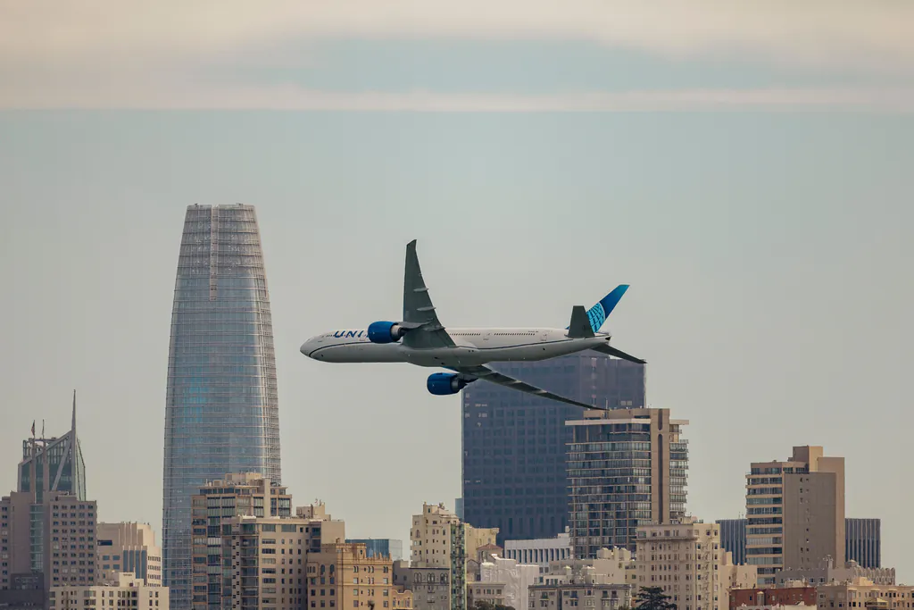 Airplane soaring above the iconic San Francisco skyline, featuring modern skyscrapers.